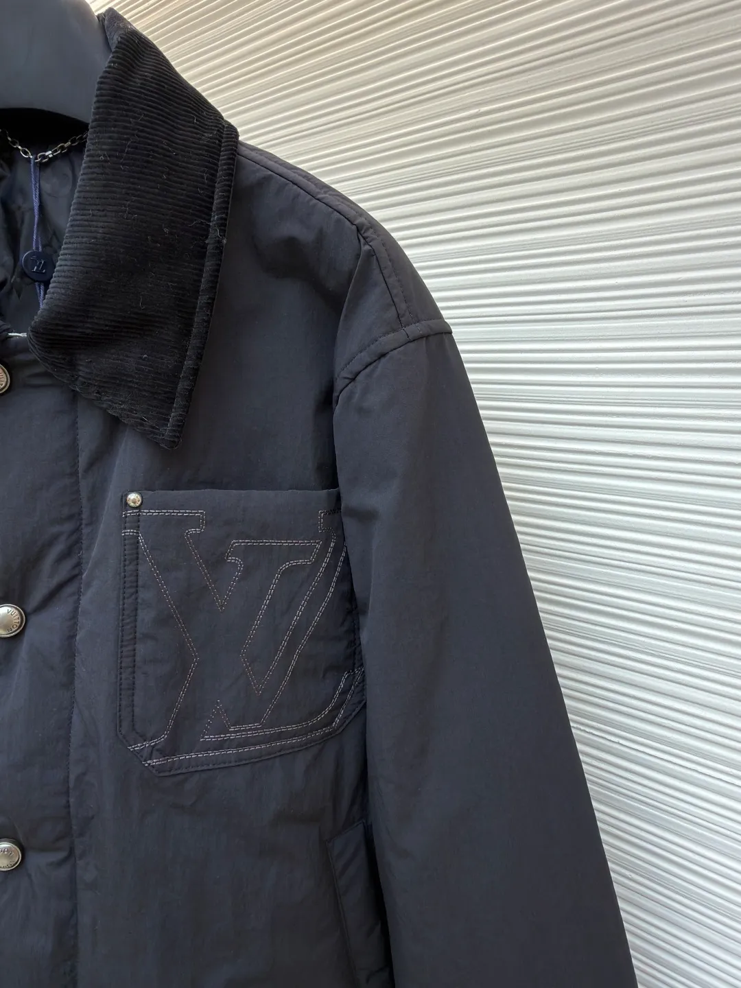 LOUIS VUITTON Corduroy collar waterproof work jacket ●Original version: purchased and developed in 19699 ●Item number: 1681946-C30 ●Fabric: nylon fabric ●Technology: embroidery production ●Color: black ●Version: fitted version ●Weight: about 550 grams ●Size: 44-46-48-50 ●Description: Made of water-repellent nylon blended fabric, the body is made of precision woven craftsmanship to create a matte texture, taking into account both lightness and stiffness. The collar is made of ribbed corduroy-effect leather, which uses trompe l'oeil techniques to simulate the texture of corduroy. It feels soft and has a retro look. The chest patch pocket adopts double-line topstitch quilting technology, embedded with three-dimensional LV letter embroidery, and reinforced with metal rivets on the edge, which is both decorative and durable. The front is equipped with pearlescent mother-of-pearl buttons, and the metal base is polished and nickel-plated, with a delicate luster and not easily oxidized. The inner lining is Damier jacquard fabric, and the quilting process is filled with light and warm fibers. The cuffs and hem are narrowed with the same fabric. The overall stitching error is controlled within 0.1cm, and the Italian workshop hand-finishes the details. The overall wiring is straight and delicate, the fabric is comfortable and soft, and the color is consistent without color difference. It can be matched with the same style to create a fashionable look and control various occasions. Customized accessories, complete with three standards, same style for men and women!